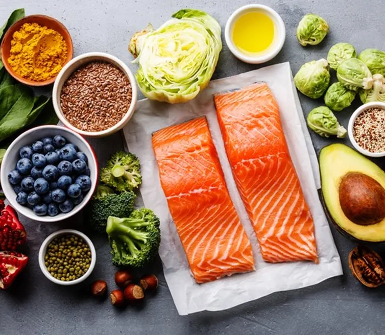Salmon, leafy greens, berries and seeds arranged as tooth-friendly whole foods
